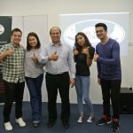 A group of people smiling and giving thumbs up, promoting Be the Voice Academy in Singapore.